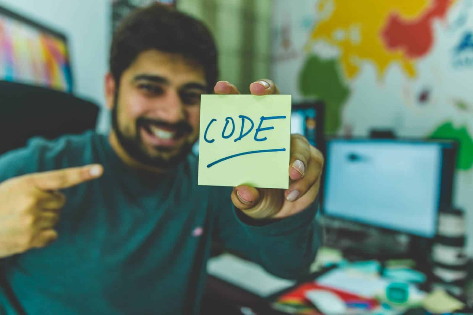 man-in-grey-sweater-holding-yellow-sticky-note-879109 code